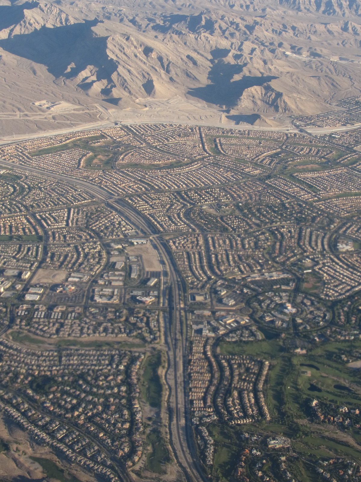 Suburban streets below the Spring Mountains, from the air over the northwest valley.